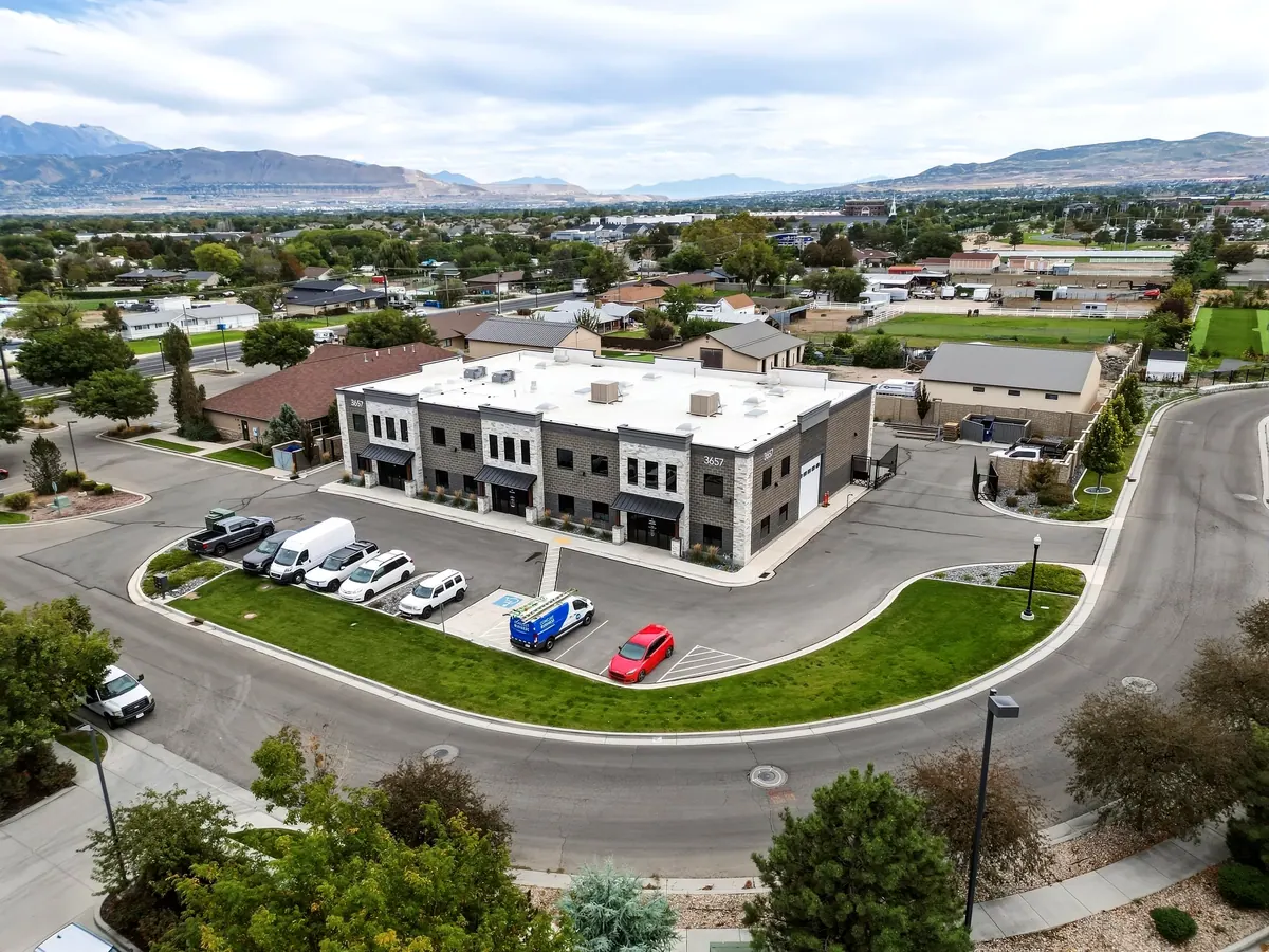 Elevated view of a two-story commercial building, adjacent road and surrounding neighborhood