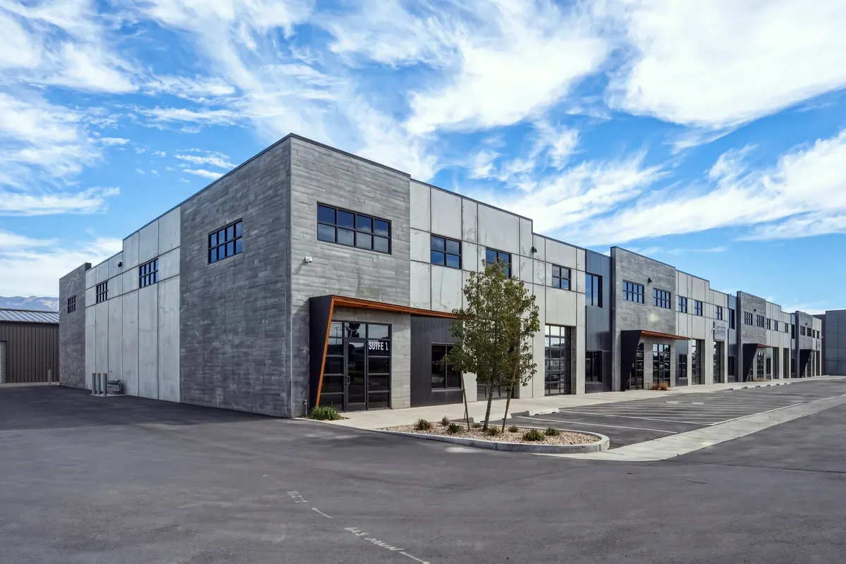 Corner perspective of the Sky Landing flex warehouse building with gray masonry facades, storefront glazing and parking