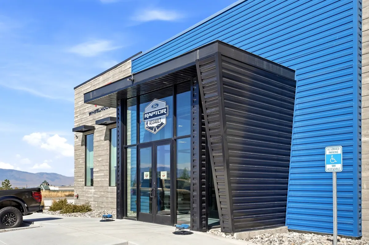 Angled close-up of the Wheelhouse racing facility glazed entrance and blue siding