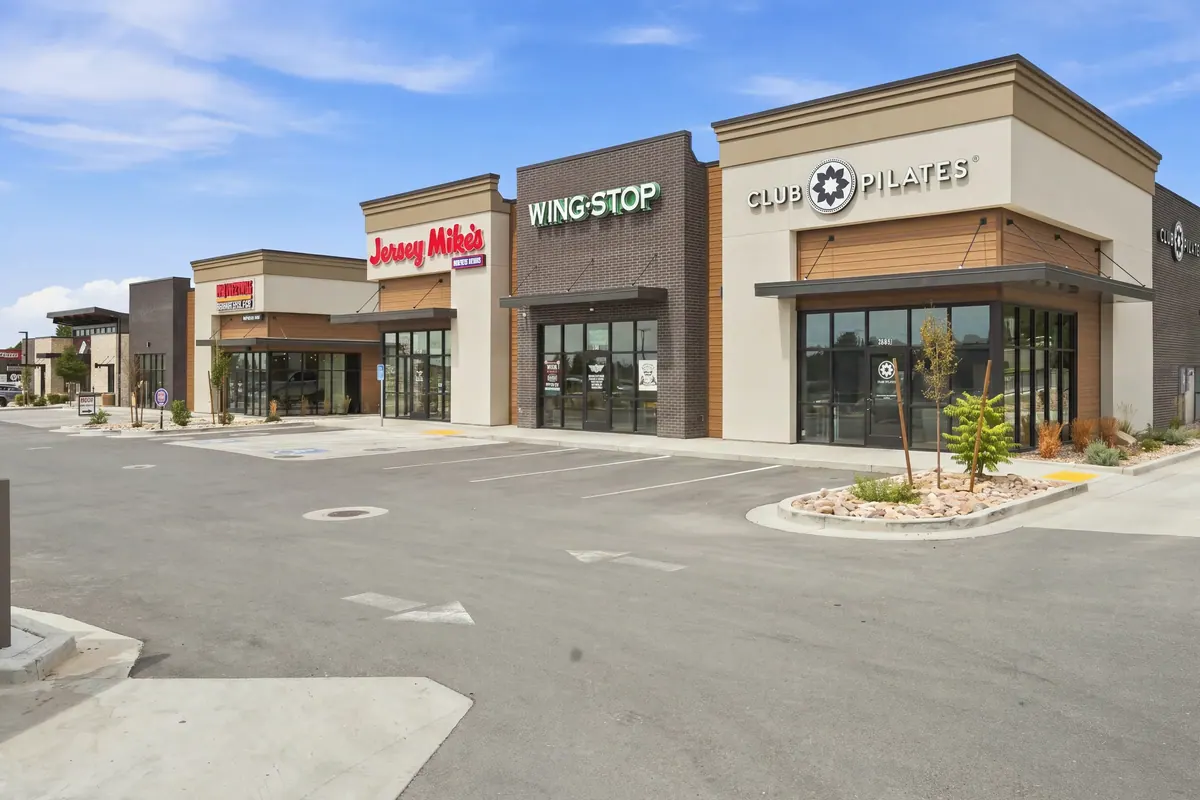 Street-level view of the North Ogden retail storefronts, including Wingstop and Club Pilates