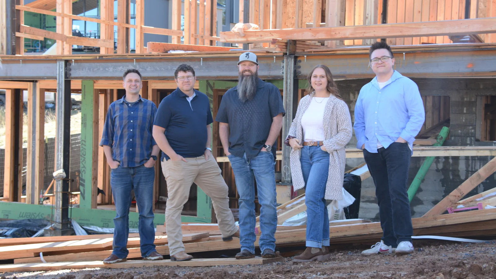 The RAD Cru standing together on a framed construction site