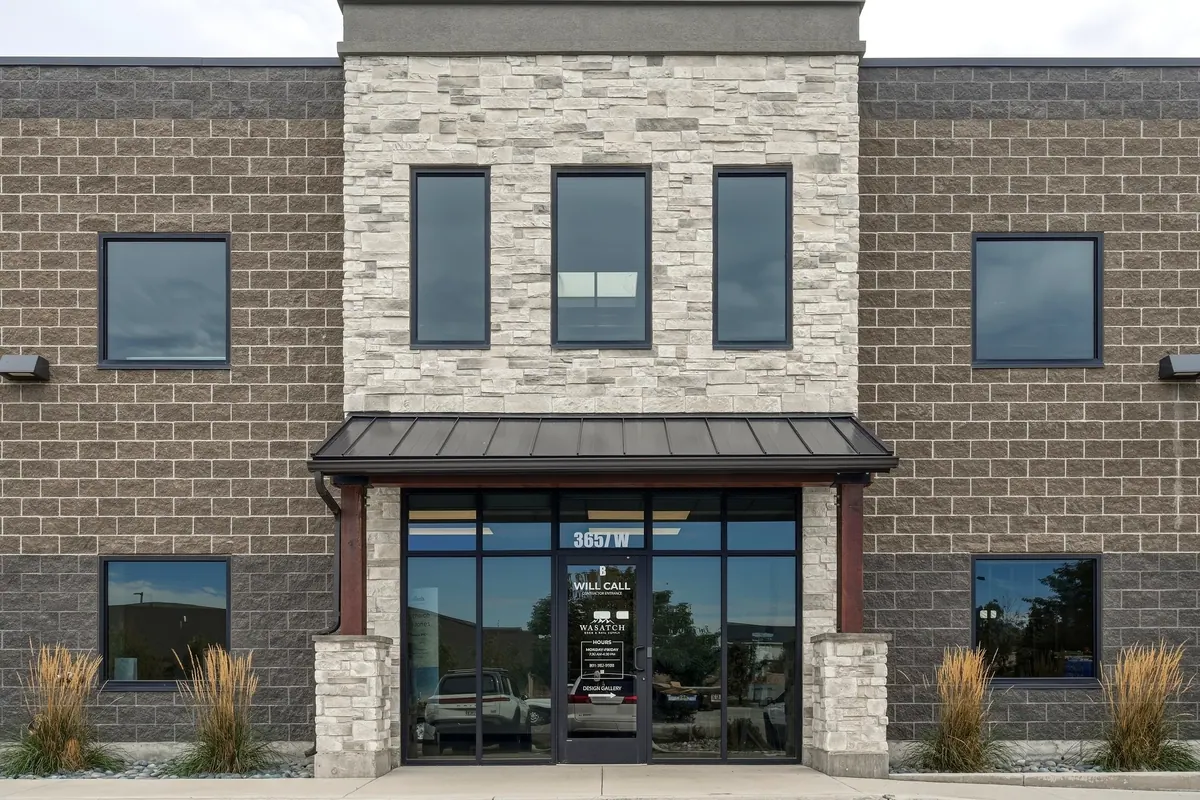 Front entrance of a brick commercial building with vertical window accents and glass doors