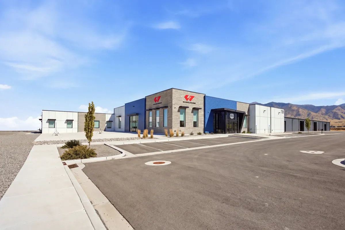 Street-level view of the Wheelhouse racing facility with multiple service bays and blue entrance