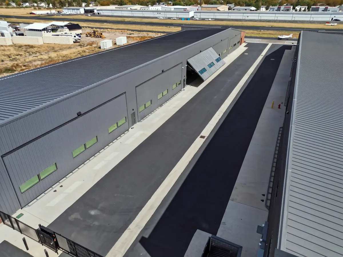 Elevated view down the paved lane between the Western Fab airplane hangar buildings
