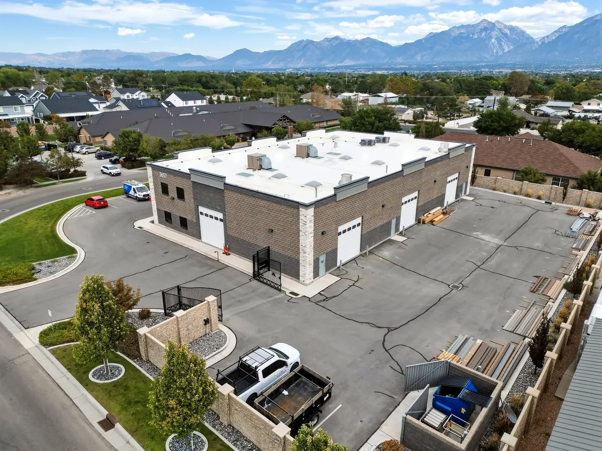 Aerial view of the rear and side of a two-story commercial building with parking lot